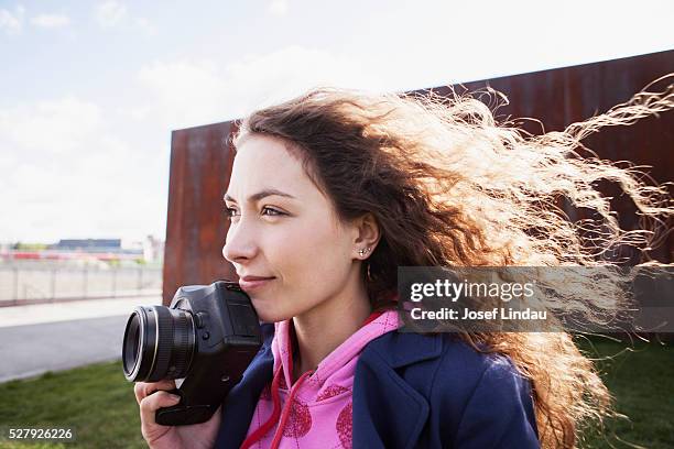 young woman thinking about an image she wants to take - josef lindau stock-fotos und bilder