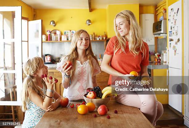 3 sisters with fruits in the kitchen - blonde fille photos et images de collection