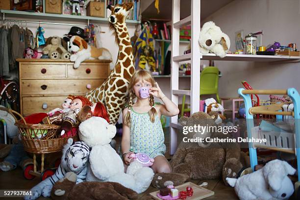 a girl in her filled bedroom - stuffed toy stock pictures, royalty-free photos & images