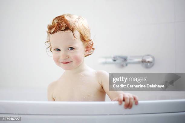 a 3 years old red-headed girl in her bath - red tub 個照片及圖片檔