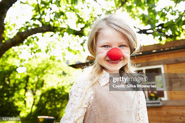 portrait of blonde girl (6-7) dressed up as clown with red nose - nez clown photos et images de collection
