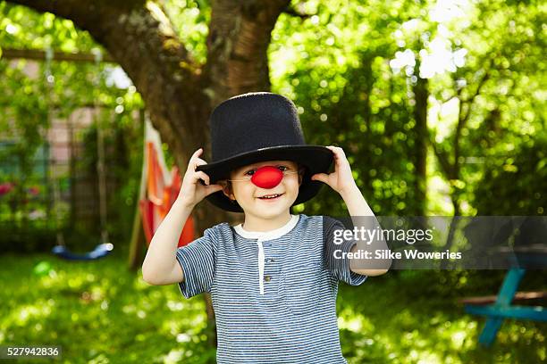 portrait of red haired boy (4-5) dressed up as clown with red nose and top hat - clown's nose stock pictures, royalty-free photos & images