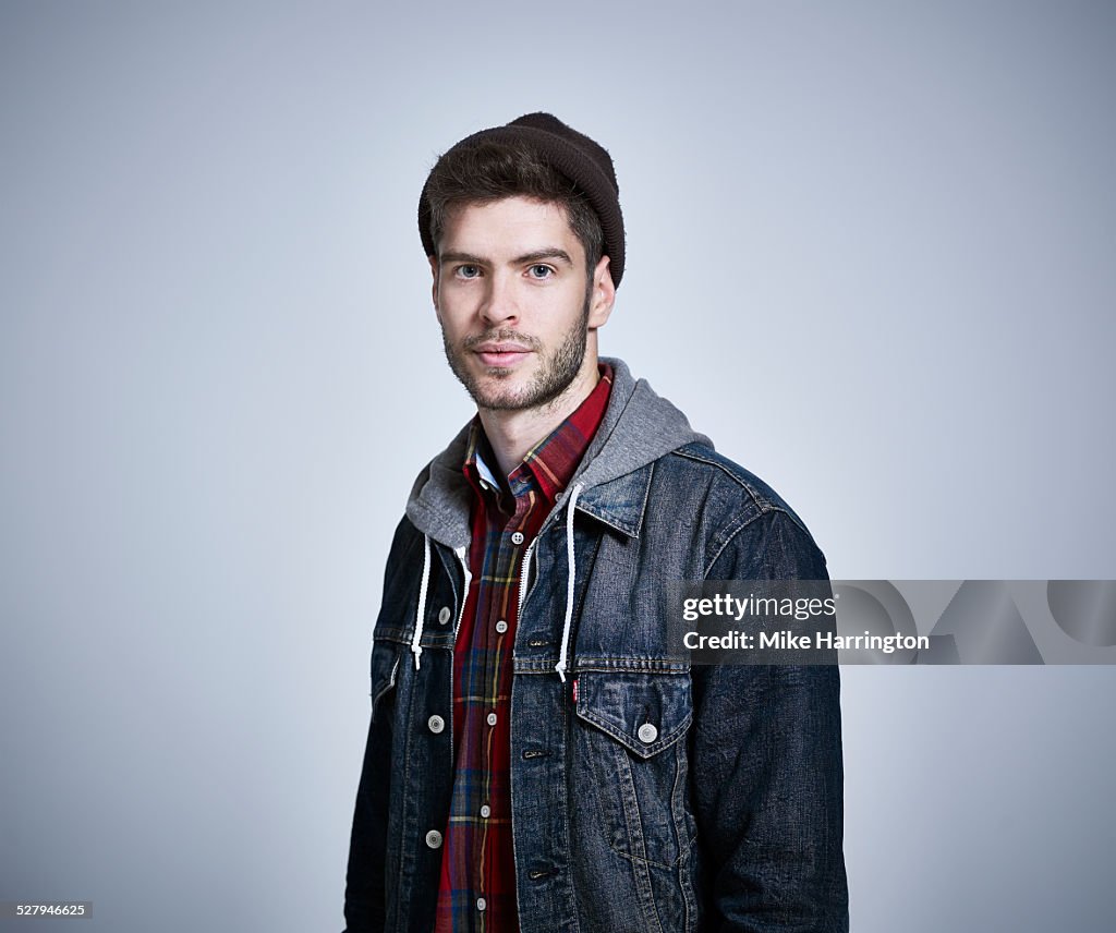 Young man in denim jacket looking to camera.