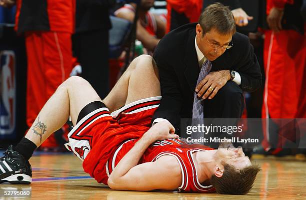 Chicago Bulls head athletic trainer Fred Tedeschi examines Andres Nocioni during the game against the Washington Wizards in Game three of the Eastern...