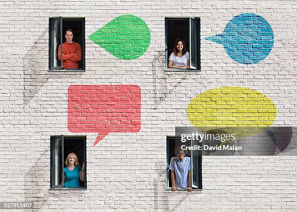 people in windows in a wall with speech-bubbles - man made object stock pictures, royalty-free photos & images