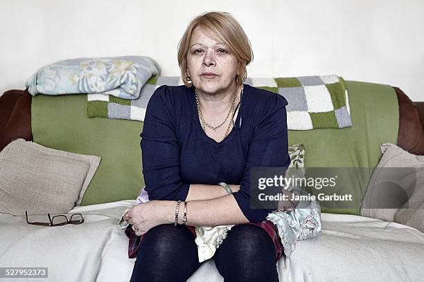 middle-aged women sat on the sofa - unhappy woman blonde glasses stock pictures, royalty-free photos & images