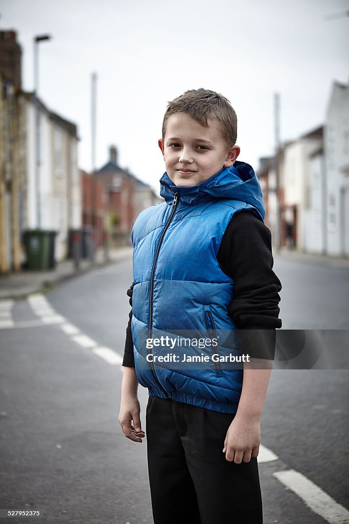 Child stood in street with cheerful expression