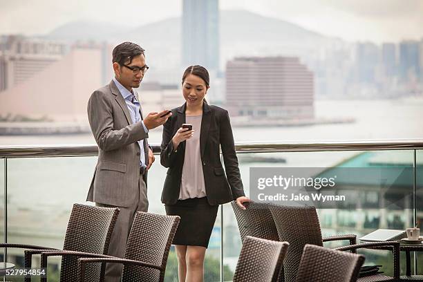 asian businesswoman & businessman in hong kong. - 2 men chatting casual office stock-fotos und bilder