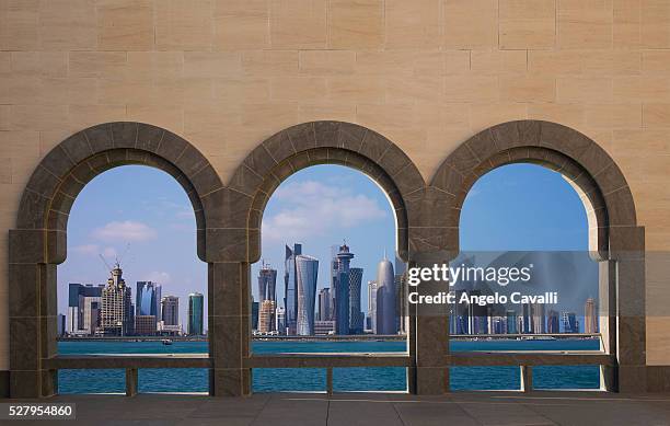 high rising buildings seen through arches, doha, qatar - doha stockfoto's en -beelden