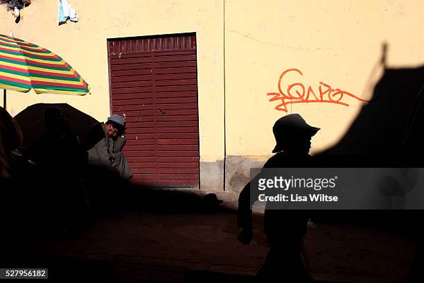Virgen del la Candelaria. A young boy walks past a man passed out from drinking during the Fiesta de la Virgen de la Candelaria is held to honour the...