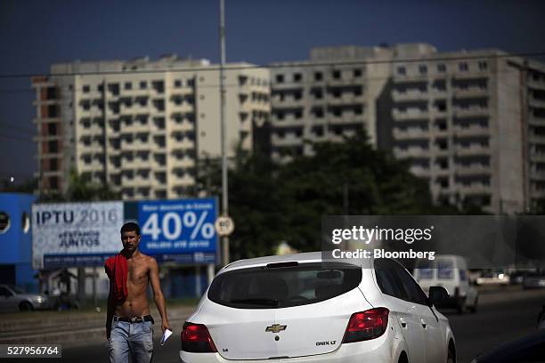 Man walks down the street in Itaborai, Brazil, on Tuesday, April 12, 2016. Just 30 miles east of the bustling Copacabana beach, Itaborai looks like...