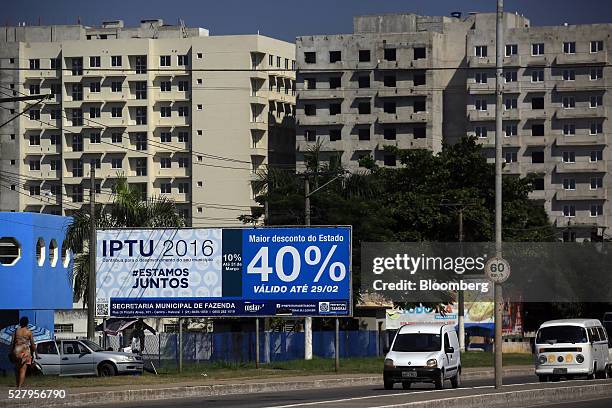 Traffic moves past unfinished buildings in Itaborai, Brazil, on Tuesday, April 12, 2016. Just 30 miles east of the bustling Copacabana beach,...