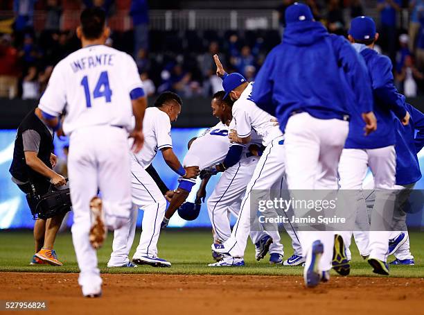 Lorenzo Cain of the Kansas City Royals celebrates with teammates after hitting the game-winning single in the bottom of the 9th inning as the Royals...