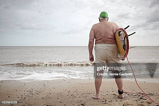 elderly overweight surfer with back to camera - looking at view stock pictures, royalty-free photos & images