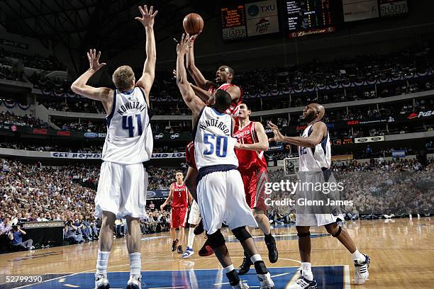 Dirk Nowitzki and Alan Henderson of the Dallas Mavericks try to block a jump shot by Tracy McGrady of the Houston Rockets in Game five of the Western...