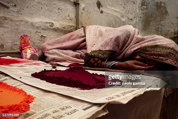 Sleeping woman next to curry and other spicy powder in a street of Benares/Varanasi, India 2008.