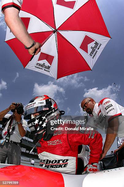 Sam Hornish, Jr., driver of the Marlboro Team Penske Dallara Toyota gets into his car during practice for the 89th Indianapolis 500-Mile Race at the...