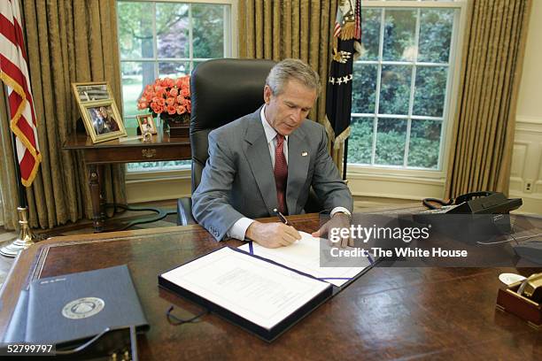 In this handout image provided by the White House, U.S. President George W. Bush signs the H.R. 1268, the "Emergency Supplemental Appropriations Act...