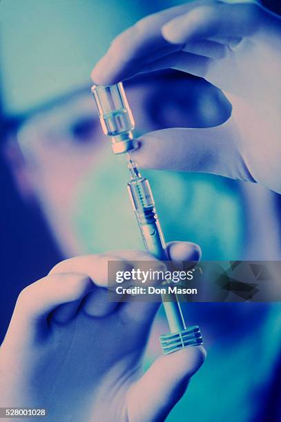 surgeon with a hypodermic syringe - anästhesist stock-fotos und bilder