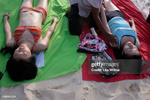 Asian tourists receive massages while laying out on White Beach in Boracay Island, the Philippines. The 4 km stretch of White beach on Boracay Island...