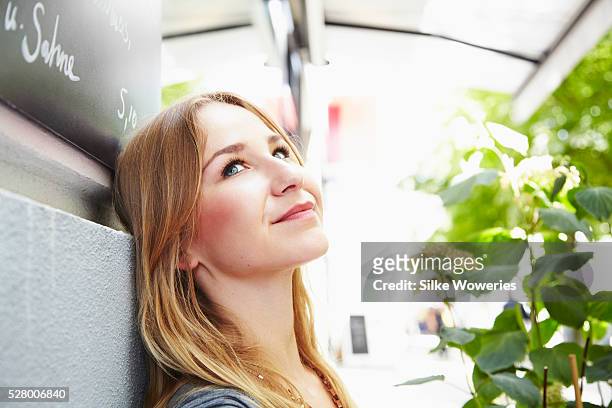woman sitting in small cafe and daydreaming - berlin cafe stock pictures, royalty-free photos & images
