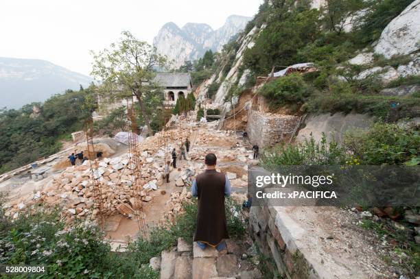 shaolin monk shi de jian overlooks construction at san huang zhai monastery on song mountain, china - dengfeng imagens e fotografias de stock