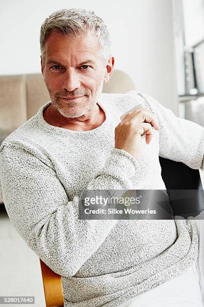 handsome middle-aged man sitting in his office - handsome people stock pictures, royalty-free photos & images