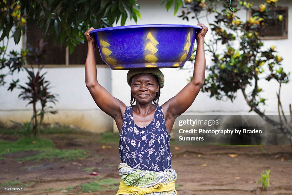 Elderly woman collects water in rural liberia