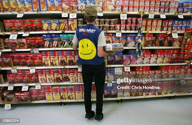 An employee restocks a shelf in the grocery section of a Wal-Mart Supercenter May 11, 2005 in Troy, Ohio. Wal-Mart, America's largest retailer and...