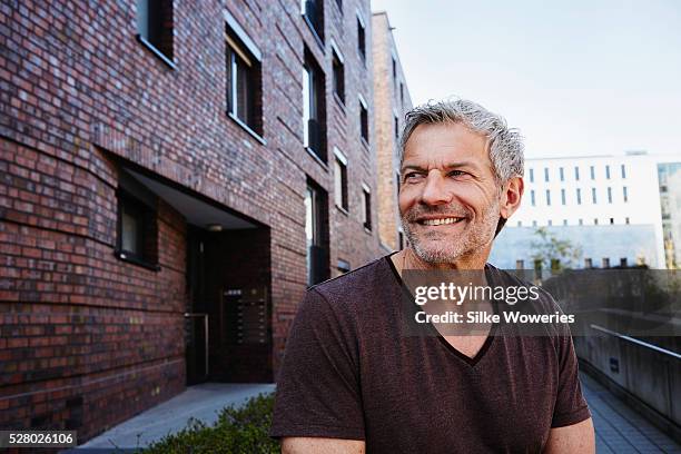 man standing in front of modern building in city - one man only stock pictures, royalty-free photos & images