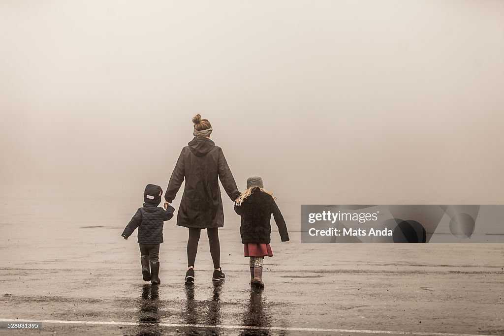 Single mother and two kids walking into fog