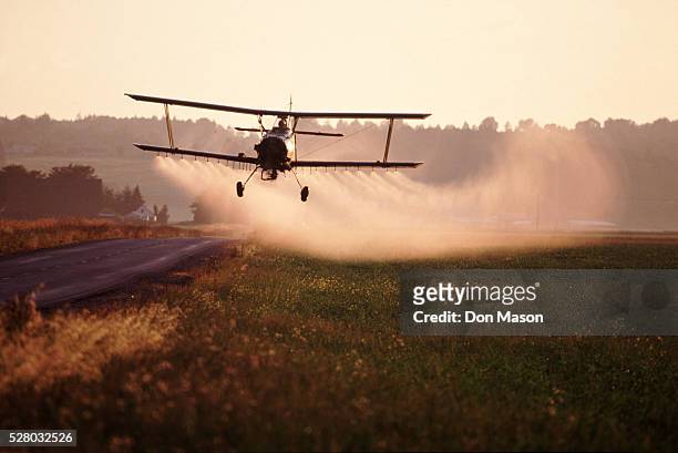 crop-dusting a field - avião biplano - fotografias e filmes do acervo