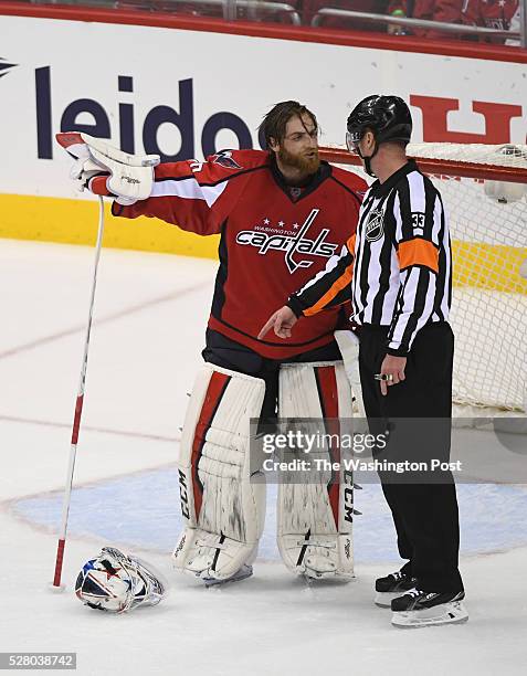 Referee Kevin Pollock tells Washington Capitals goalie Braden Holtby to pick his mask up off the ice after throwing it in protest during the second...