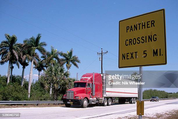 Sign warns travelers of upcoming panther traffic along a freeway near the Florida Everglades wilderness.
