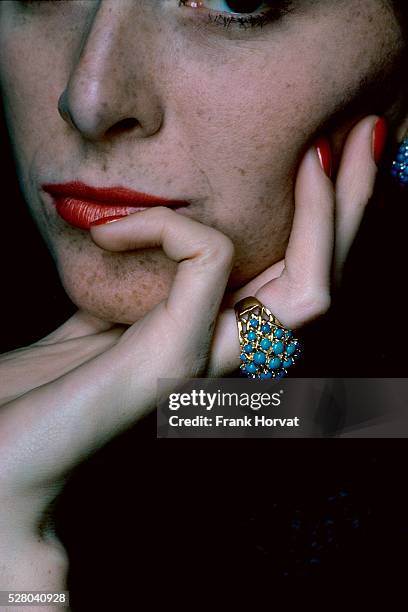 Close-up of model's mouth and nails with color by Christian Dior, wearing turquoise ring by Cartier.