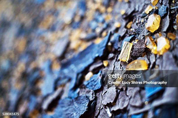 broken yellow glass and blue slate. - lucy shires stock-fotos und bilder