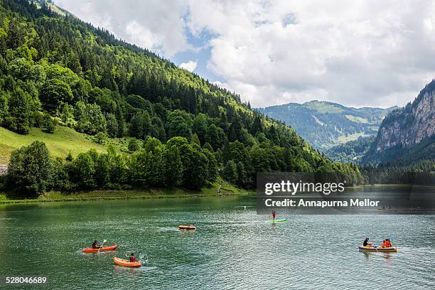 canoes on lac de montriond in the french alps - morzine stock pictures, royalty-free photos & images