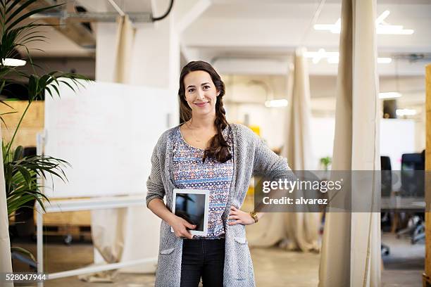 geschäftsfrau mit hand an der hüfte und halte digitaltablett - portrait of cool creative businesswoman at office stock-fotos und bilder