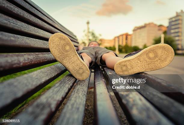 sole shoes closeup of boy lying on a wooden bench - girls soles stock pictures, royalty-free photos & images