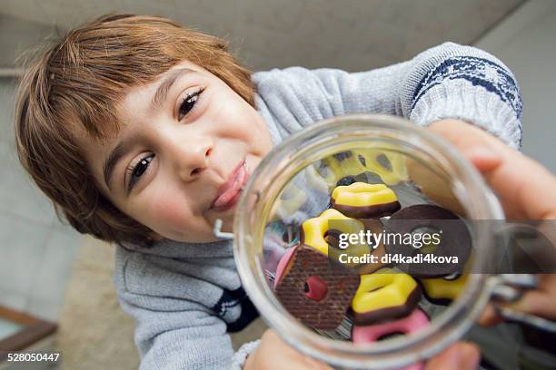 a boy holding a jar of biscuits - cookies jar stock pictures, royalty-free photos & images