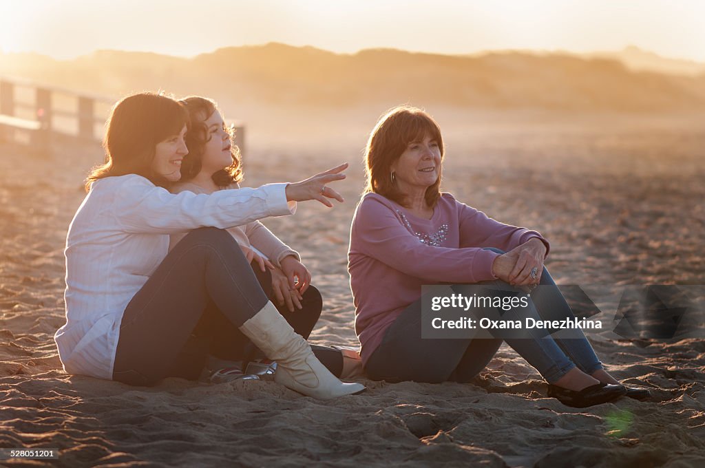 Grandmother, mother and granddaughter on the beach