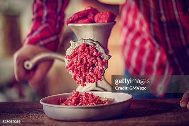 fresh minced meat in a mincer - vleesmolen stockfoto's en -beelden