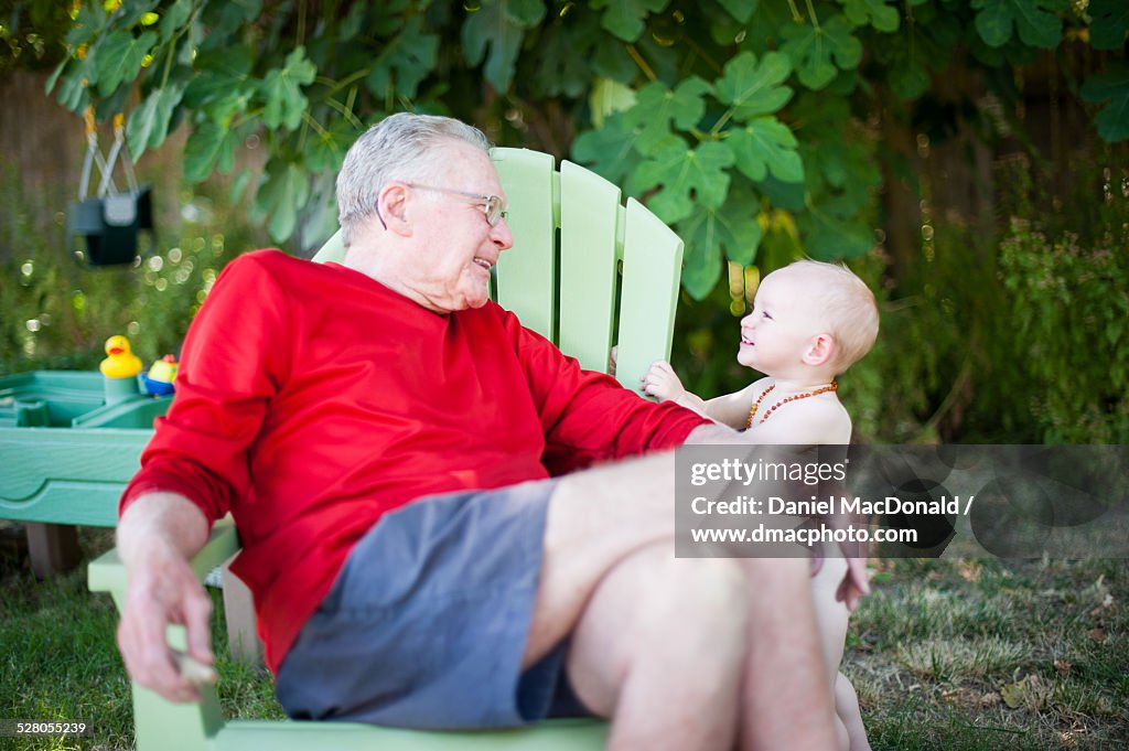 Grandfather and baby granddaughter smiling