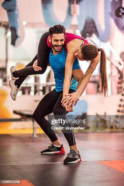 young happy man exercising with his girlfriend in a gym. - flirting gym stock pictures, royalty-free photos & images