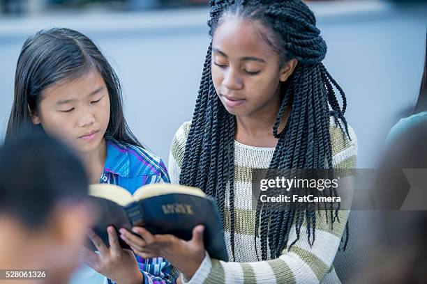 reading the bible together - bible stock pictures, royalty-free photos & images