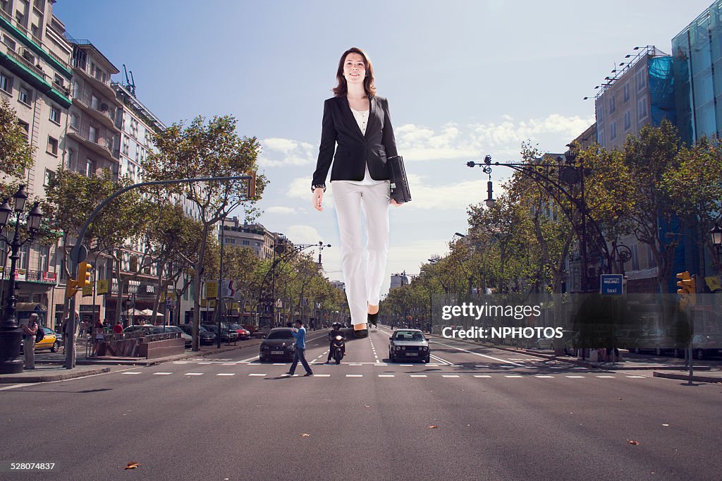 Giant businesswoman walking