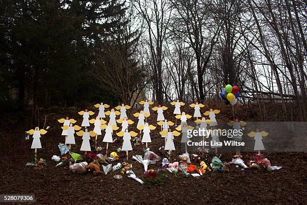Twenty-seven wooden angel figures placed in a wooded area beside the road in Sandy Hook after the mass shootings at Sandy Hook Elementary School,...
