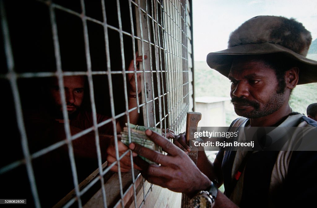 Miner Sells Gold to Dealer Through Bars of Hut, Papua New Guinea