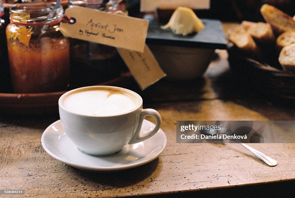 Capuccino in white cup on the old table