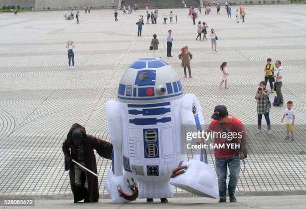 Star Wars fan, dressed as R2D2 robot, arrives during the annual Star Wars Day in Taipei on May 4, 2016. - Some 100 star wars fans dress the different...